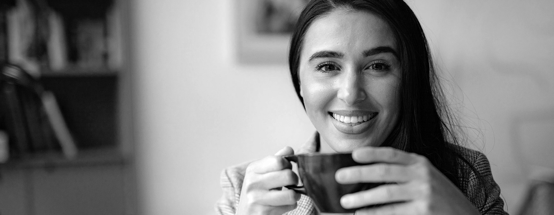 lifestyle image of a smiling woman with a cup of coffee